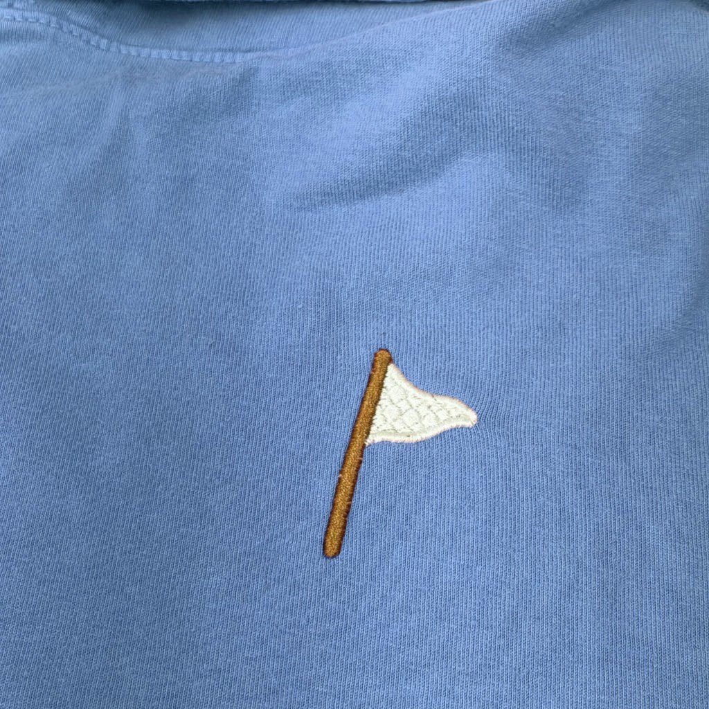 Moment Golf quilted flag logo embroidered on a soft coral pink cotton hooded pullover