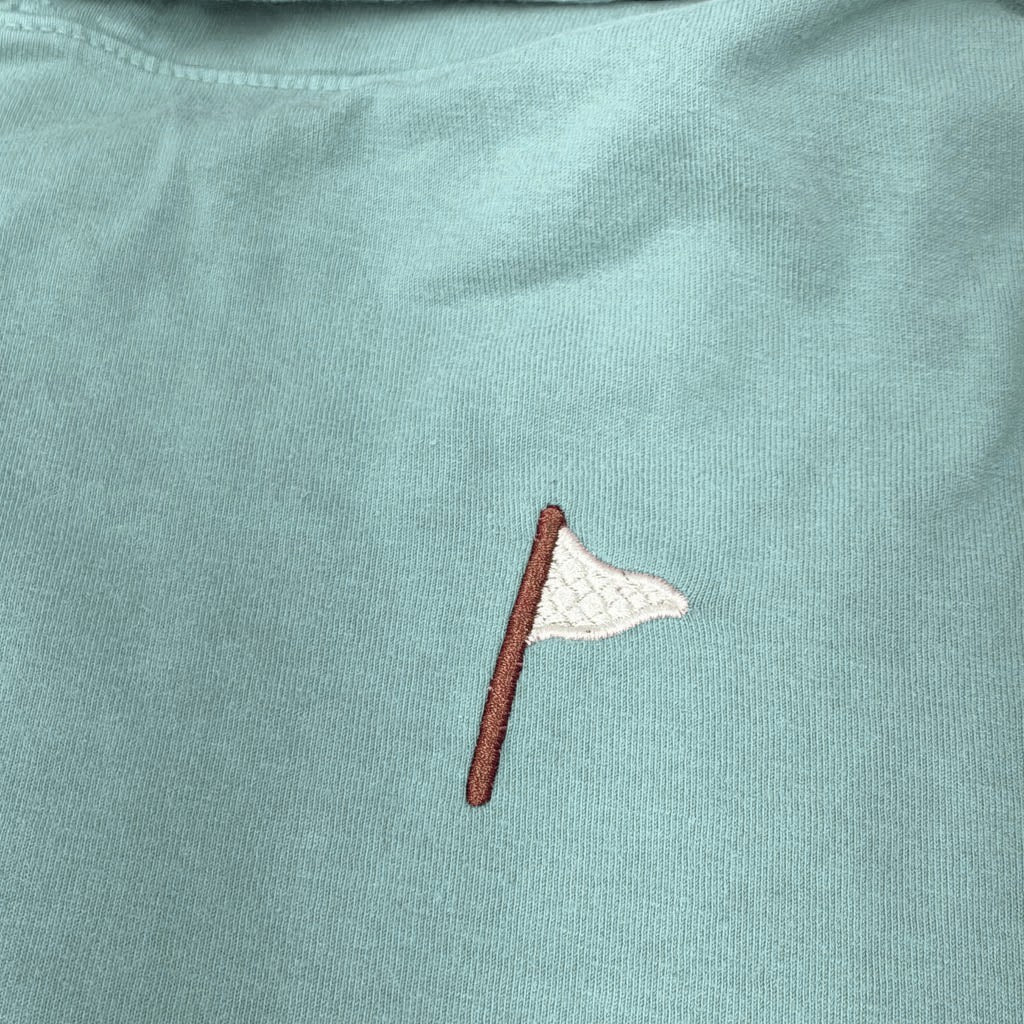 Moment Golf quilted flag logo embroidered on a soft coral pink cotton hooded pullover