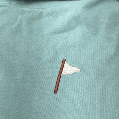 Moment Golf quilted flag logo embroidered on a soft coral pink cotton hooded pullover